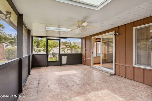 unfurnished sunroom featuring a skylight and ceiling fan