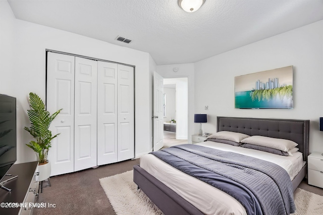 bedroom featuring a closet, dark carpet, and a textured ceiling