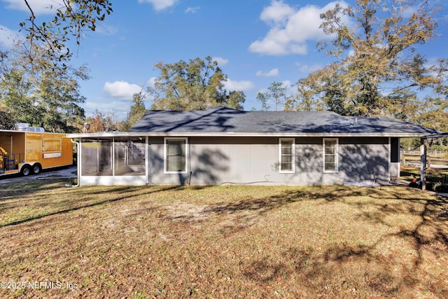 back of property with a yard and a sunroom