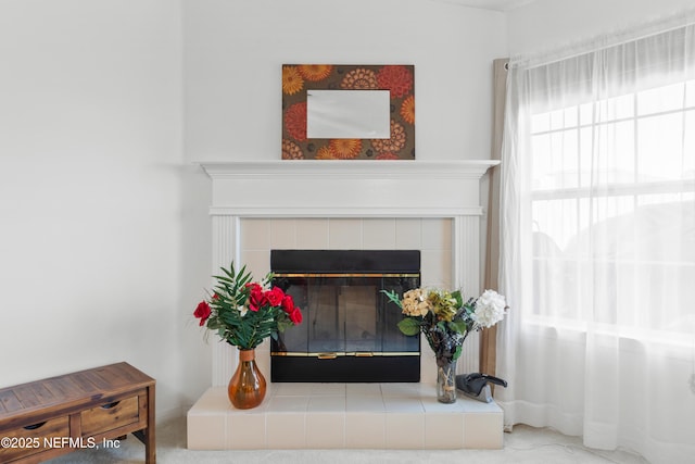 interior details featuring carpet flooring and a tiled fireplace