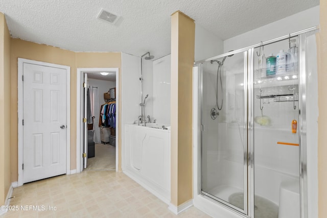 bathroom featuring a textured ceiling and walk in shower