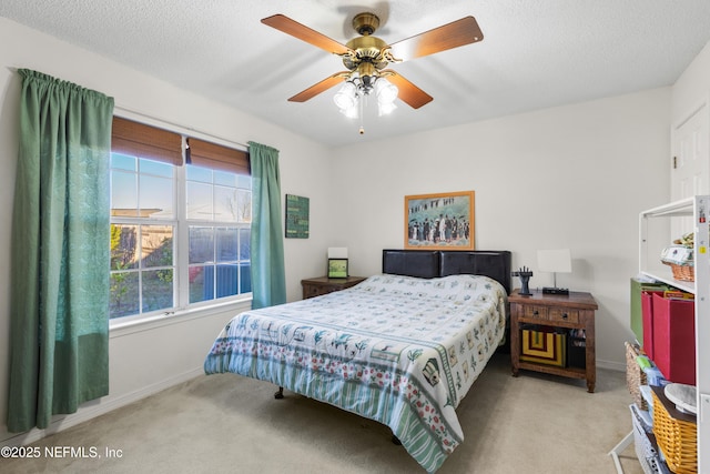 bedroom with multiple windows, ceiling fan, light carpet, and a textured ceiling