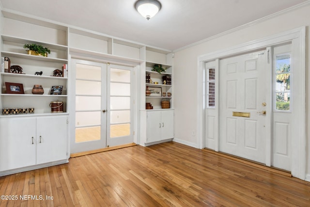 entryway featuring french doors, ornamental molding, and light hardwood / wood-style flooring