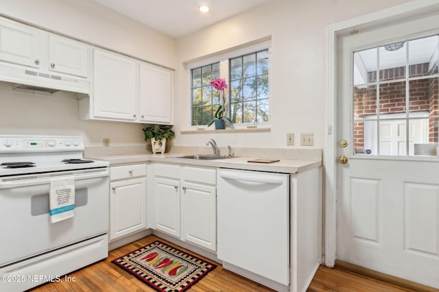 kitchen with white appliances, white cabinetry, sink, and light hardwood / wood-style flooring