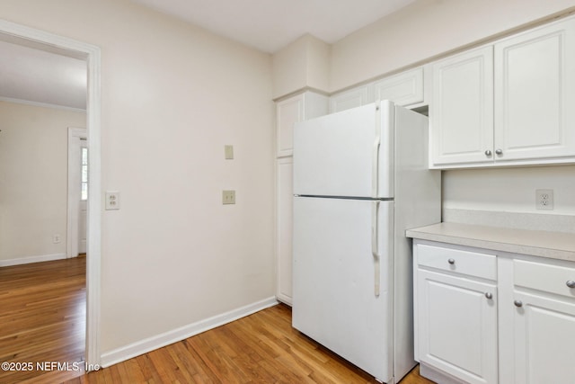 kitchen featuring white cabinets, light wood-type flooring, and white refrigerator