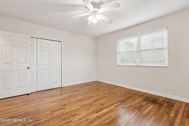 unfurnished bedroom with hardwood / wood-style floors, a closet, and ceiling fan