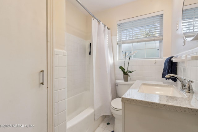 full bathroom with shower / tub combo, tile walls, a wealth of natural light, and vanity