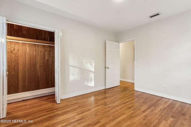 unfurnished bedroom with hardwood / wood-style flooring and a closet