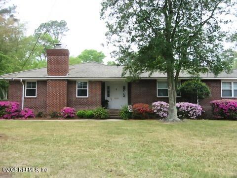 5140 Ortega Blvd, Jacksonville, FL 32210 - ranch-style home featuring a front lawn, a chimney, and brick siding