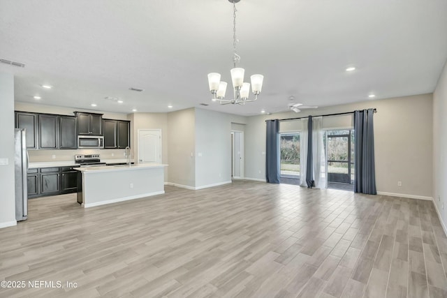 interior space with sink, ceiling fan with notable chandelier, and light wood-type flooring