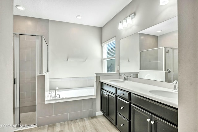 bathroom featuring plus walk in shower, wood-type flooring, and vanity