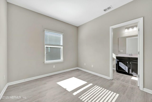 spare room featuring sink and light hardwood / wood-style flooring