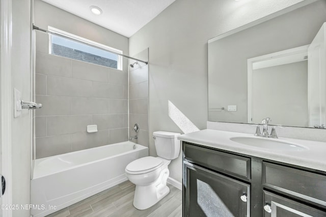 full bathroom with vanity, toilet, tiled shower / bath combo, and wood-type flooring