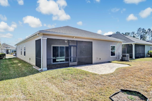 rear view of property with central AC unit, a patio area, a sunroom, and a lawn