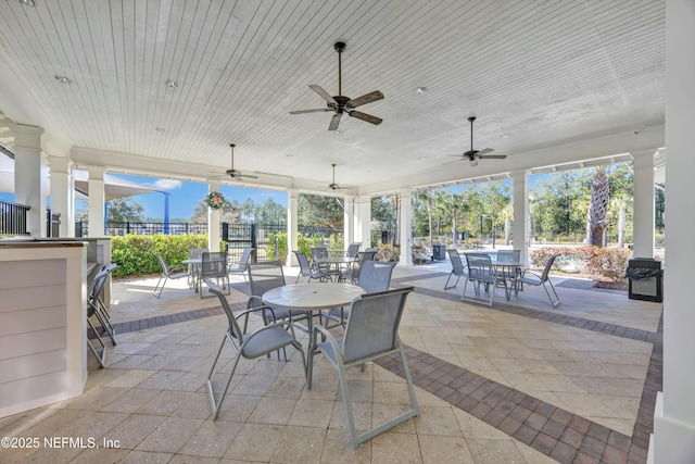 view of patio / terrace featuring ceiling fan, a grill, and exterior bar