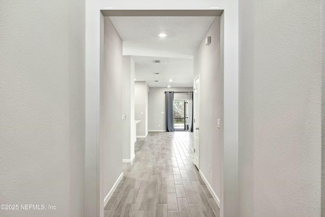 corridor with light hardwood / wood-style flooring