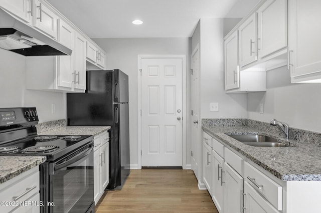 kitchen with black appliances, white cabinets, sink, light hardwood / wood-style flooring, and light stone counters