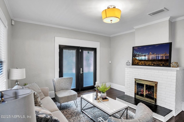 living room featuring a brick fireplace, french doors, dark hardwood / wood-style floors, and ornamental molding