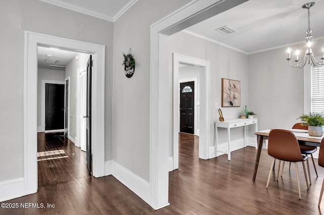 dining space with dark hardwood / wood-style floors, crown molding, and an inviting chandelier