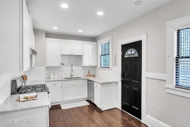 kitchen featuring white cabinetry, sink, dark hardwood / wood-style flooring, backsplash, and appliances with stainless steel finishes