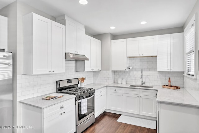 kitchen featuring white cabinets, appliances with stainless steel finishes, decorative backsplash, and sink