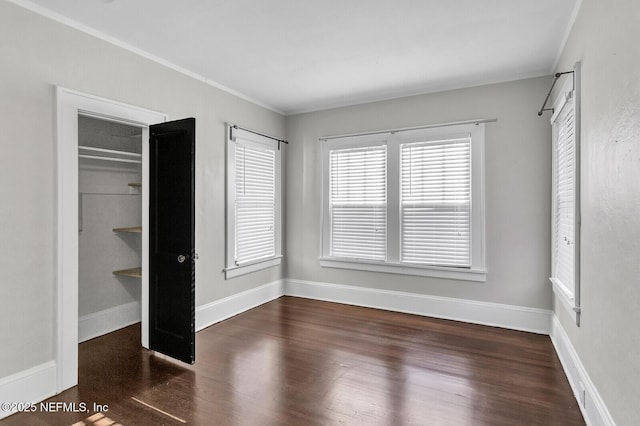 unfurnished bedroom featuring a closet, dark hardwood / wood-style flooring, and ornamental molding