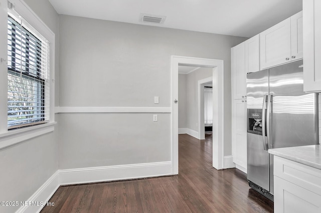 kitchen with white cabinets, dark hardwood / wood-style floors, stainless steel fridge, and a healthy amount of sunlight