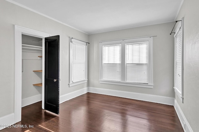 unfurnished bedroom with a closet, dark wood-type flooring, and ornamental molding