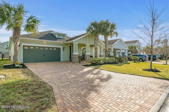 view of front of house with covered porch, a front yard, and a garage