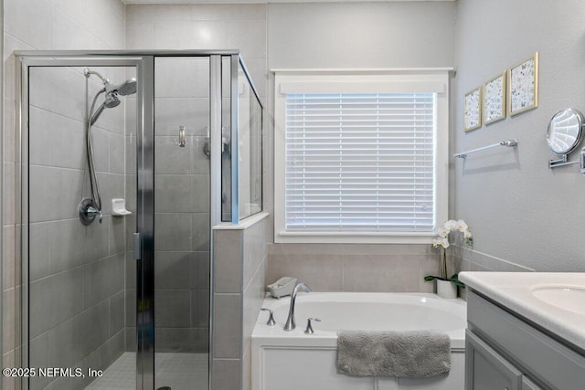 bathroom featuring plus walk in shower, vanity, and a wealth of natural light