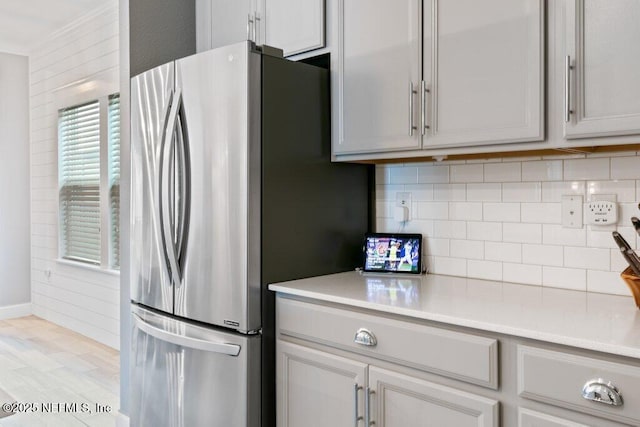 kitchen featuring decorative backsplash, stainless steel fridge, and light wood-type flooring