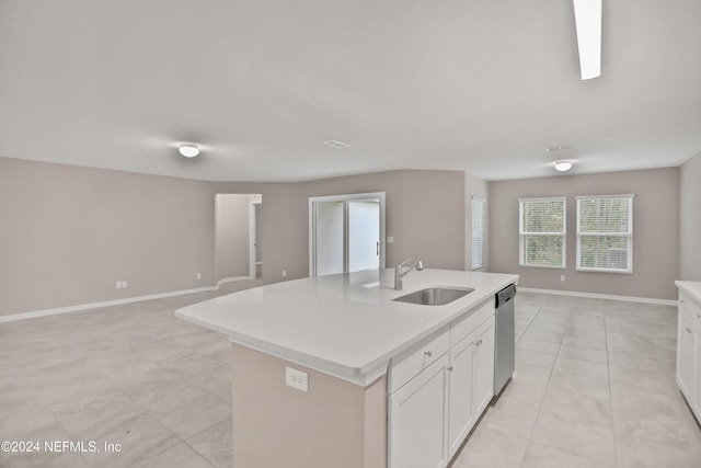 kitchen with dishwasher, a kitchen island with sink, sink, light tile patterned floors, and white cabinetry