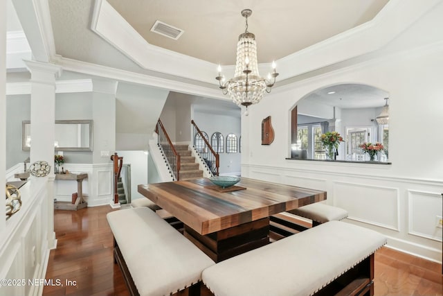 dining space featuring a tray ceiling, dark hardwood / wood-style floors, ornamental molding, and a chandelier