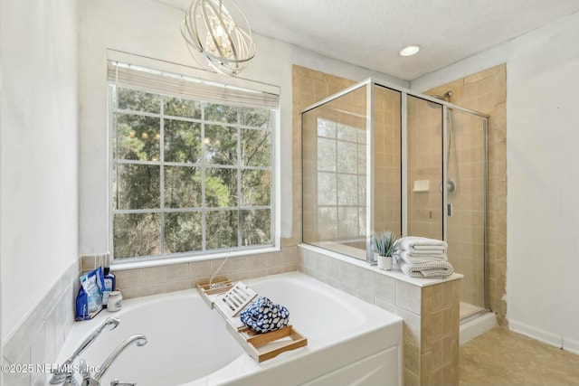 bathroom featuring plus walk in shower and a textured ceiling