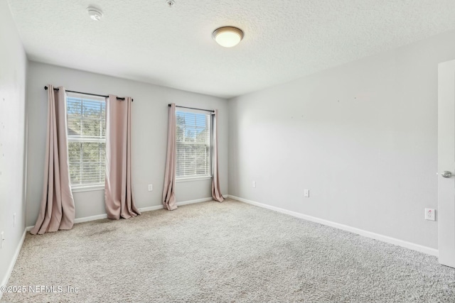 unfurnished room with a textured ceiling and carpet floors