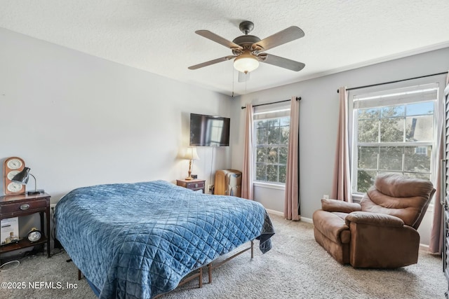 bedroom featuring ceiling fan, a textured ceiling, and carpet flooring