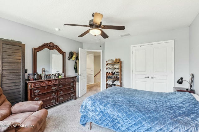 carpeted bedroom with ceiling fan and a closet