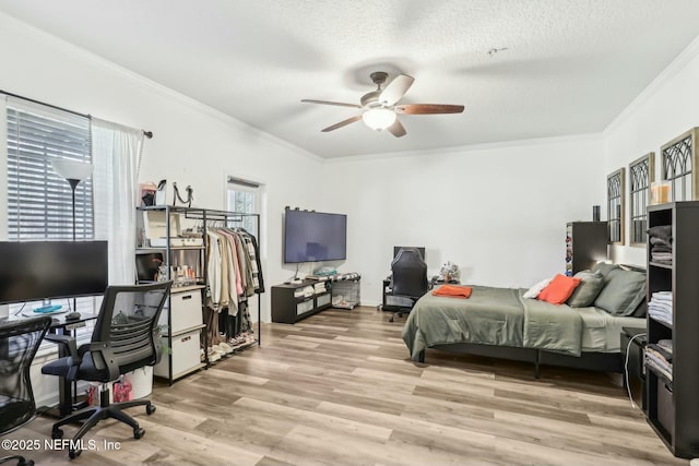 bedroom featuring ceiling fan, multiple windows, and ornamental molding