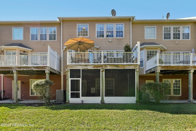 back of house featuring a lawn and a sunroom