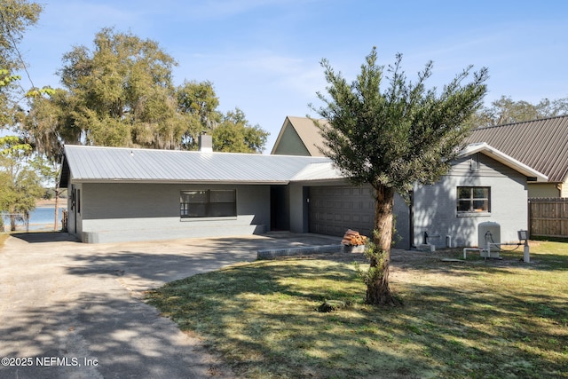 ranch-style house featuring a front yard and a garage