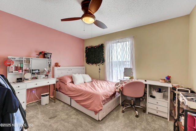 bedroom featuring ceiling fan, light carpet, and a textured ceiling