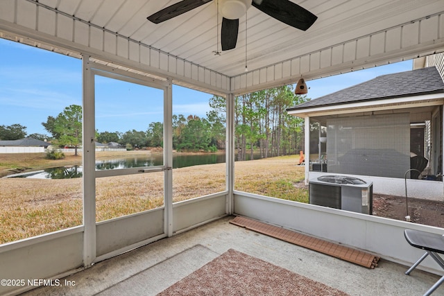 unfurnished sunroom with ceiling fan and a water view