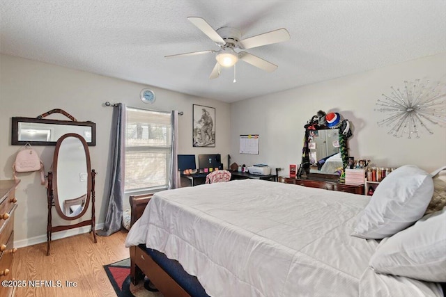 bedroom with ceiling fan, light hardwood / wood-style flooring, and a textured ceiling