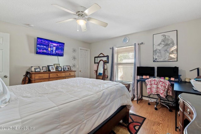 bedroom with ceiling fan, a textured ceiling, and light hardwood / wood-style flooring