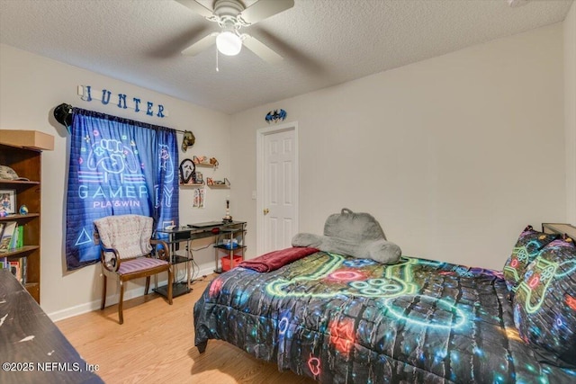 bedroom featuring ceiling fan, hardwood / wood-style floors, and a textured ceiling