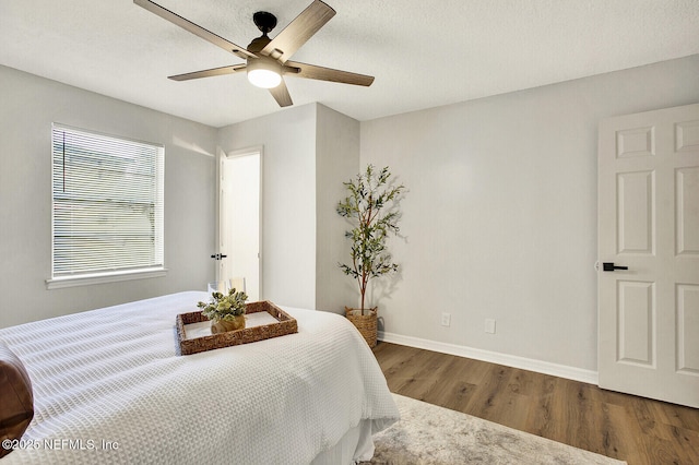 bedroom with ceiling fan and dark hardwood / wood-style flooring