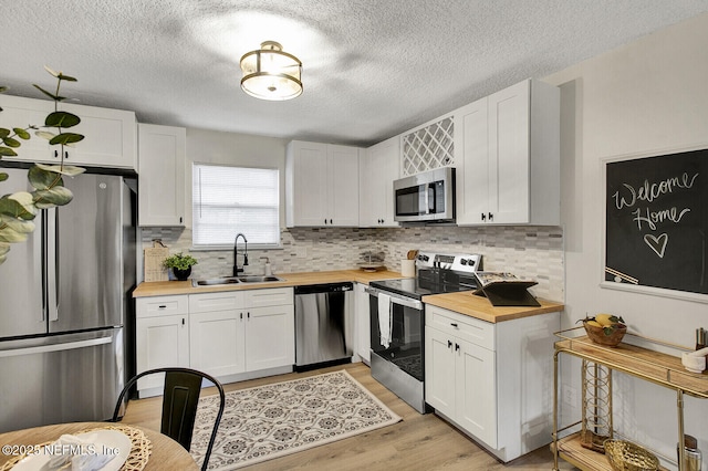 kitchen featuring wood counters, white cabinetry, sink, and appliances with stainless steel finishes