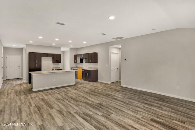 kitchen featuring a center island with sink, dark brown cabinetry, wood-type flooring, and sink