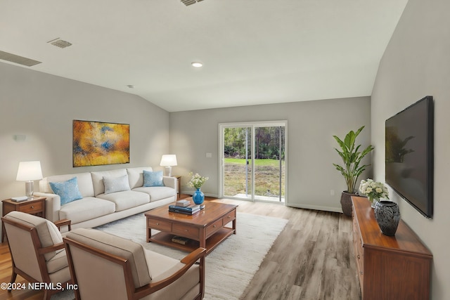 living room featuring vaulted ceiling and light hardwood / wood-style flooring