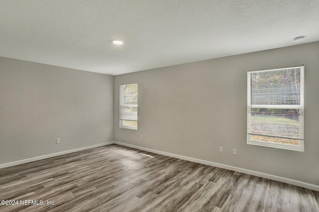 spare room featuring hardwood / wood-style flooring and a textured ceiling